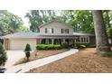 Two story home with attached garage, brick accents and covered front porch with trimmed shrubs and walkway at 125 Amesbury Ln, Cary, NC 27511