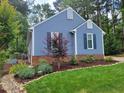 Attractive blue home showcasing manicured landscaping and beautiful yard at 1304 Greenside Dr, Raleigh, NC 27609