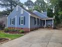 Stylish blue house with a cozy front porch and a long driveway at 1304 Greenside Dr, Raleigh, NC 27609