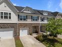 Attractive townhome featuring stone accents, a single-car garage, and well-manicured landscaping at 1394 Southpoint Trl, Durham, NC 27713