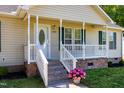 Close-up of the home's welcoming front porch with decorative door and brick-lined stairs at 1443 Smokey Mountain Dr, Zebulon, NC 27597