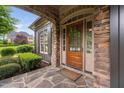Charming front entrance with stone accents, a wooden door, and well-maintained landscaping at 1508 Samuel Wait Ln, Wake Forest, NC 27587