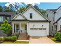 Inviting home showcasing a covered porch, brick stairs, and an attached two-car garage, offering classic curb appeal at 151 Monteith Dr, Chapel Hill, NC 27516