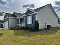 Side view of a home with tidy landscaping, showcasing its architectural design and yard space at 152 Springtooth Dr, Zebulon, NC 27597