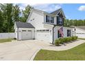 Spacious two-car garage complementing a well-maintained home with an American flag and manicured greenery at 159 Mitchell Manor Dr, Angier, NC 27501