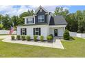 Inviting two-story home with white siding, black accents, and a neatly landscaped front yard under a clear blue sky at 159 Mitchell Manor Dr, Angier, NC 27501