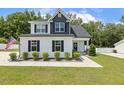 Attractive two-story home boasts fresh landscaping, black shutters, and modern design elements, nestled in a serene setting at 159 Mitchell Manor Dr, Angier, NC 27501