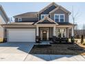 Charming home showcasing a two-car garage and a cozy front porch at 162 Sugar Pine Drive, Franklinton, NC 27525