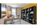 Bright office space with desk, chair, and a large shelving unit against a bright yellow accent wall at 177 Holton St, Smithfield, NC 27577