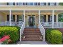 Welcoming front porch with elegant columns, brick steps, and charming landscaping at 1952 Combine Cir, Apex, NC 27502