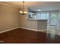 Open dining area with modern chandelier and hardwood floors, leading to the kitchen at 210 Standish Dr Dr, Chapel Hill, NC 27517