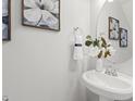 Stylish powder room with pedestal sink, decorative mirror, and fresh decor at 223 Morgan Brook Way, Rolesville, NC 27571