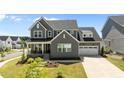 Charming two-story home features a welcoming front porch, well-kept lawn, and a two-car garage at 236 Artisan Park Dr, Wake Forest, NC 27587
