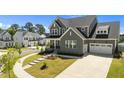 Attractive gray home with neat landscaping, front porch, long driveway and a two-car garage in a lovely neighborhood at 236 Artisan Park Dr, Wake Forest, NC 27587