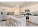 Bright kitchen boasts white cabinetry, stainless steel appliances, and a central island with barstool seating at 24 Grove Township Way, Angier, NC 27501