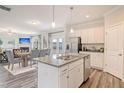 Open-concept kitchen features stainless steel appliances and a granite island, flowing into the dining and living areas at 24 Grove Township Way, Angier, NC 27501
