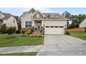 Inviting home featuring a manicured lawn, stone details, and a convenient two-car garage at 302 Kinney Glenn Ct, Durham, NC 27713