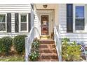 Charming brick steps lead to a welcoming front door adorned with decorative plants and stylish fixtures at 311 Pate St, Apex, NC 27502