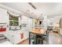 Bright kitchen featuring white cabinetry, stainless steel sink, and a center island with seating at 311 Pate St, Apex, NC 27502