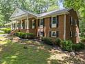 Brick home with a welcoming front porch, black shutters, and manicured bushes at 3204 Manor Ridge Dr, Raleigh, NC 27603
