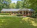A spacious brick home with a manicured lawn, black shutters, and a covered front porch at 3204 Manor Ridge Dr, Raleigh, NC 27603