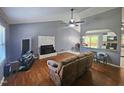 Cozy living room with fireplace, hardwood floors, and ceiling fan, open to the kitchen at 3612 Satellite Ct, Raleigh, NC 27604