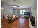 Comfortable living room showcasing hardwood floors, a fireplace, ceiling fan and neutral paint at 3612 Satellite Ct, Raleigh, NC 27604