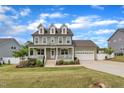 Inviting two-story home with an attached garage and landscaped front yard at 384 Grey Hawk Dr, Garner, NC 27529