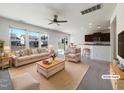 Bright, open-concept living room with neutral decor, large windows, and seamless flow to dining and kitchen at 4169 Weavers Pond Dr, Zebulon, NC 27597