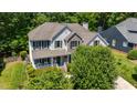 Beautiful home with a welcoming front porch, gray siding, stone accents, and a lush green lawn at 4608 Regency Dr, Durham, NC 27713