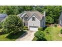Beautiful home with a two-car garage, gray siding, stone accents, and a lush, tree-filled yard at 4608 Regency Dr, Durham, NC 27713
