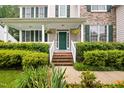Charming home exterior with a cozy covered porch, lush landscaping and attractive front door at 4608 Regency Dr, Durham, NC 27713