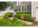 Home's inviting entrance features lush bushes and a welcoming 'Welcome' sign at 4608 Regency Dr, Durham, NC 27713
