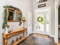 Warm foyer with a decorative table, mirror, and slate tile flooring at 506 Wildwood Ln, Graham, NC 27253
