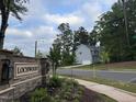 Street view of the Lochwood community sign, surrounded by trees and greenery, highlighting the neighborhood's entrance at 509 Olive Branch Rd, Durham, NC 27703