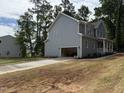 View of home featuring an attached two-car garage, gray siding, and neatly landscaped yard at 509 Olive Branch Rd, Durham, NC 27703