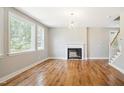 Bright living room with a fireplace, wood floors, and large windows at 509 Olive Branch Rd, Durham, NC 27703