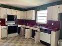 Galley kitchen featuring white cabinets, laminate countertops, and essential appliances at 601 Crestview Dr, Durham, NC 27712