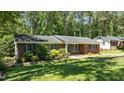 Cozy brick home featuring a neatly kept lawn and mature trees at 612 Harvest Ln, Raleigh, NC 27606