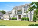 Charming home featuring gray shingle and white brick siding, with a lush green lawn and beautiful landscaping at 6502 New Market Way, Raleigh, NC 27615