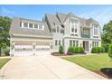 Lovely home featuring white brick, shingle siding, manicured lawn, and a two-car garage at 6502 New Market Way, Raleigh, NC 27615