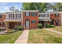Traditional brick townhomes showcasing well-manicured lawns and charming curb appeal with colorful flowerbeds at 6565 New Market Way, Raleigh, NC 27615