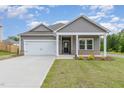 Charming home with gray siding, white trim, a two-car garage, and a manicured front yard at 680 Winesap Dr, Graham, NC 27253