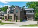 Beautiful home with a stone and wood exterior, featuring a well-maintained lawn and landscaping at 702 Wimbleton Dr, Raleigh, NC 27609