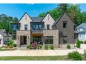 Stunning two-story home with stone accents, manicured landscaping, and classic architectural details at 702 Wimbleton Dr, Raleigh, NC 27609