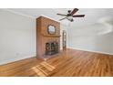 Living room featuring brick fireplace, hardwood floors, and a ceiling fan at 717 Fairfield St, Burlington, NC 27215