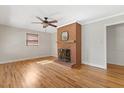 Living room with brick fireplace, hardwood floors, and ceiling fan at 717 Fairfield St, Burlington, NC 27215