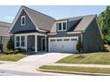Charming home with blue siding, a two-car garage, manicured lawn, and a welcoming front porch at 725 Banningford Rd, Cary, NC 27518