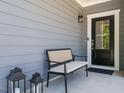 Inviting front porch with a cozy bench, decorative lanterns, and a stylish front door at 725 Banningford Rd, Cary, NC 27518
