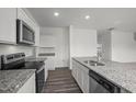Bright kitchen featuring granite countertops, stainless steel appliances, and hardwood flooring at 801 Kenyon Spring Dr, Zebulon, NC 27597